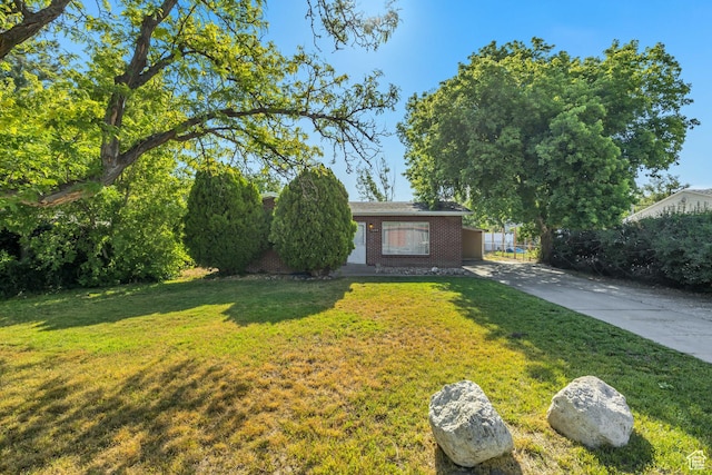 3409 S Maple Way, Salt Lake City, UT 84119 - view of front facade featuring brick siding, a front lawn, and driveway