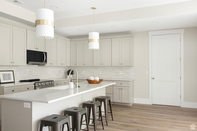 14277 S Keely Ct, Bluffdale, UT 84065 - kitchen featuring appliances with stainless steel finishes, a breakfast bar, decorative backsplash, light wood finished floors, and recessed lighting