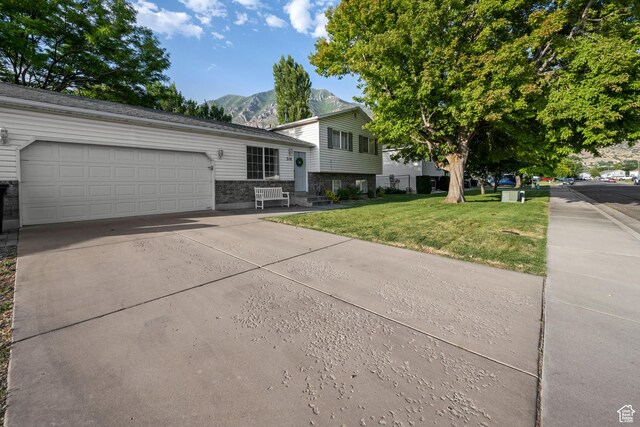 318 W 850 N, Springville, UT 84663 - split level home featuring a mountain view, a front lawn, concrete driveway, and a garage