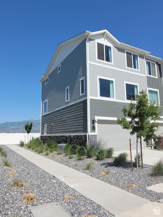 3947 N Aggie Dr Unit 301, Eagle Mountain, UT 84005 - view of side of home with an attached garage, a mountain view, and stone siding