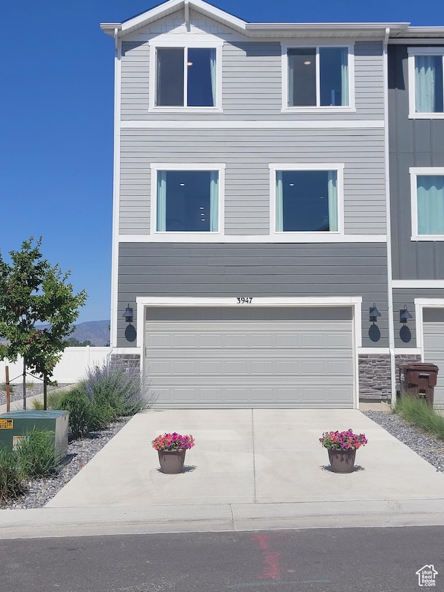 3947 N Aggie Dr Unit 301, Eagle Mountain, UT 84005 - view of front of home featuring a garage, concrete driveway, and stone siding