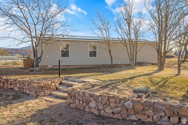 2627 E Cactus Rd, Moab, UT 84532 - view of property exterior featuring crawl space, a metal roof, and a lawn