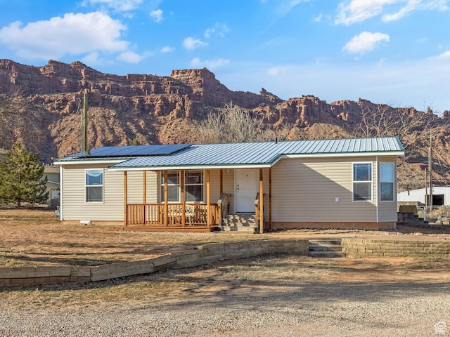 2627 E Cactus Rd, Moab, UT 84532 - manufactured / mobile home featuring a porch, a mountain view, solar panels, a metal roof, and driveway