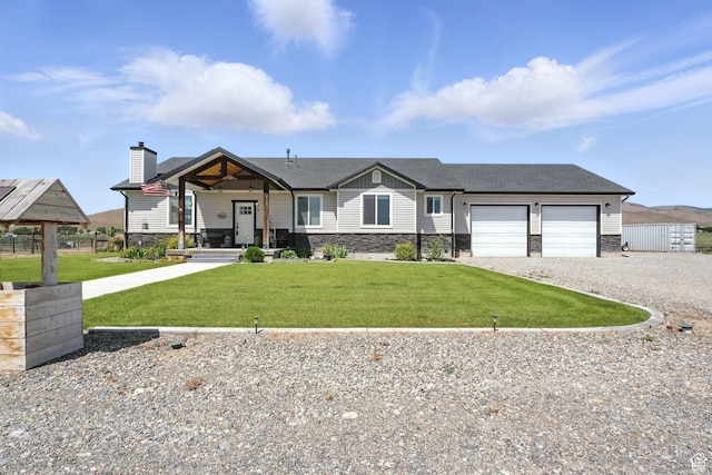 968 S 5400 W, Malad City, ID 83252 - view of front of property featuring driveway, stone siding, an attached garage, and a front lawn