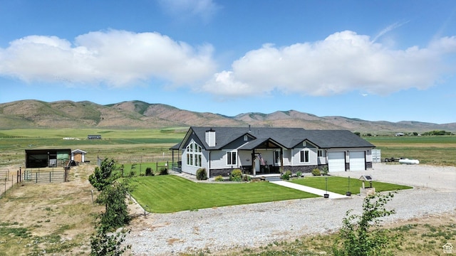 968 S 5400 W, Malad City, ID 83252 - view of front of property featuring driveway, an attached garage, stone siding, a mountain view, and a rural view