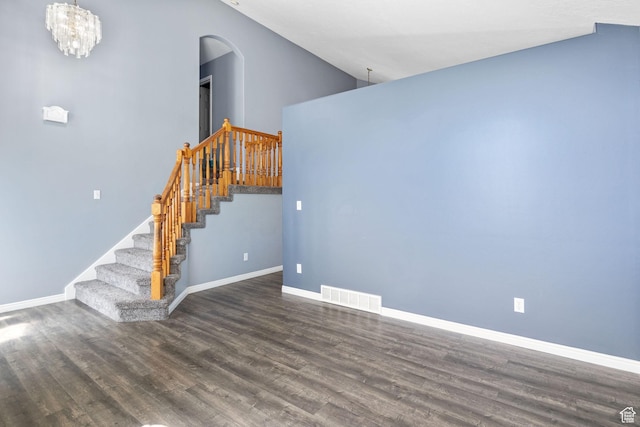 2177 N 125 W, Layton, UT 84041 - unfurnished living room featuring arched walkways, wood finished floors, stairs, and a chandelier