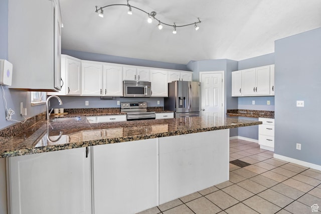 2177 N 125 W, Layton, UT 84041 - kitchen featuring stainless steel appliances, a peninsula, white cabinetry, light tile patterned flooring, and dark stone countertops