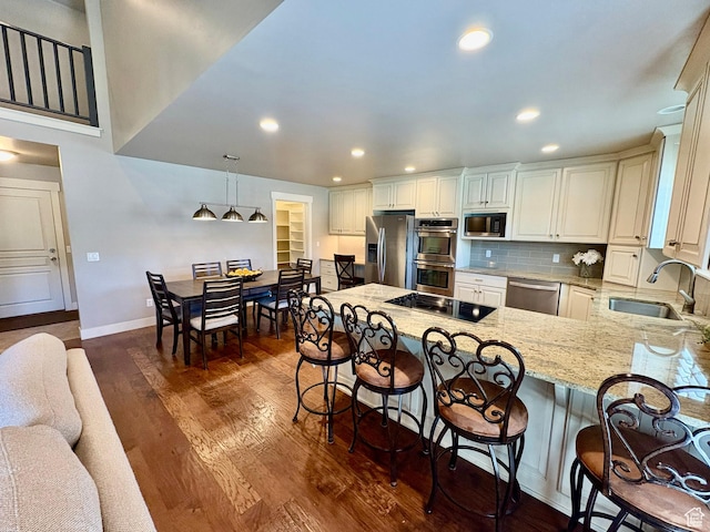 966 E 2810 S, Heber City, UT 84032 - kitchen with stainless steel appliances, a peninsula, light stone countertops, dark wood-style flooring, and a kitchen breakfast bar