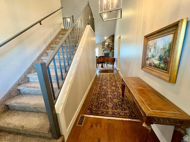 966 E 2810 S, Heber City, UT 84032 - stairs featuring a towering ceiling, wood finished floors, a stone fireplace, and a chandelier