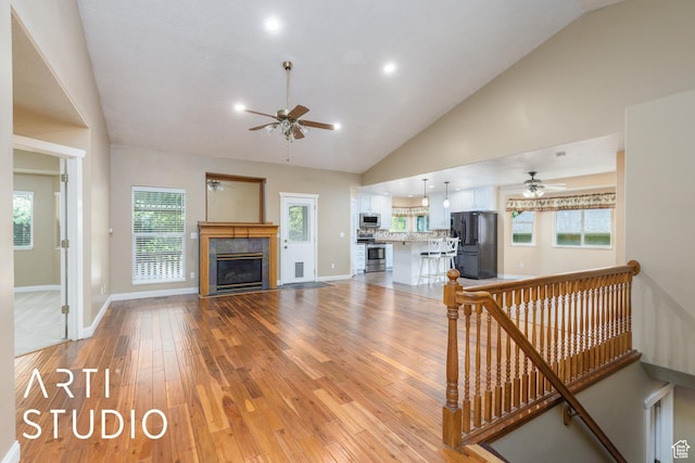 2063 N 775 E, North Ogden, UT 84414 - living room featuring ceiling fan, vaulted ceiling, light wood-style floors, a glass covered fireplace, and recessed lighting
