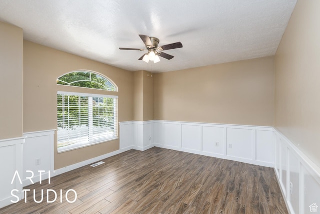 2063 N 775 E, North Ogden, UT 84414 - empty room with ceiling fan, dark wood-style floors, a wainscoted wall, a decorative wall, and a textured ceiling