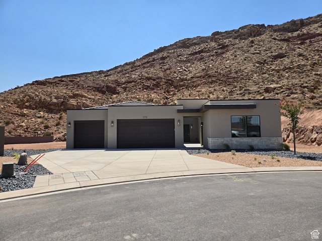 3716 E Padre Cv Unit 4094, Washington, UT 84780 - contemporary house with a garage, stucco siding, a mountain view, concrete driveway, and stone siding