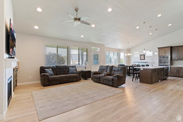 1381 W 425 S, Layton, UT 84041 - living room featuring ceiling fan, light wood finished floors, a fireplace, recessed lighting, and a chandelier