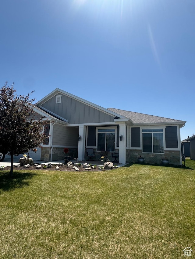 5593 W 5550 S, Hooper, UT 84315 - view of front of house featuring stone siding, board and batten siding, and a front lawn