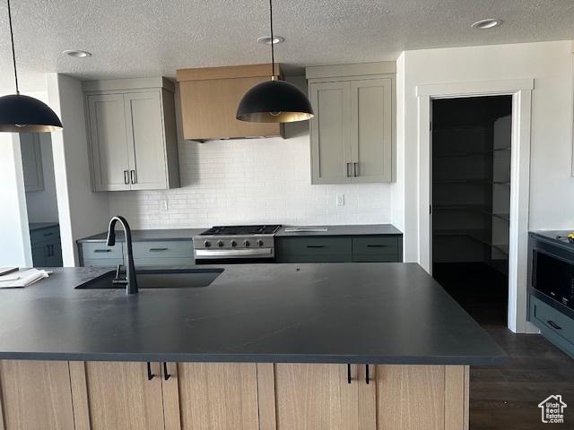 3581 W 725 S Unit 105, West Weber, UT 84401 - kitchen with range, dark countertops, decorative backsplash, a textured ceiling, and dark wood finished floors