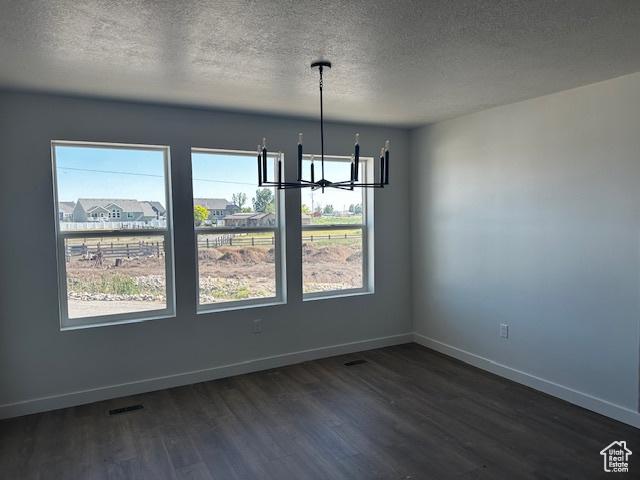 3581 W 725 S Unit 105, West Weber, UT 84401 - unfurnished dining area featuring a chandelier, dark wood-style flooring, and a textured ceiling
