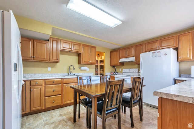 6088 W Graceland Way, West Jordan, UT 84081 - kitchen with white appliances, under cabinet range hood, light countertops, a textured ceiling, and brown cabinets