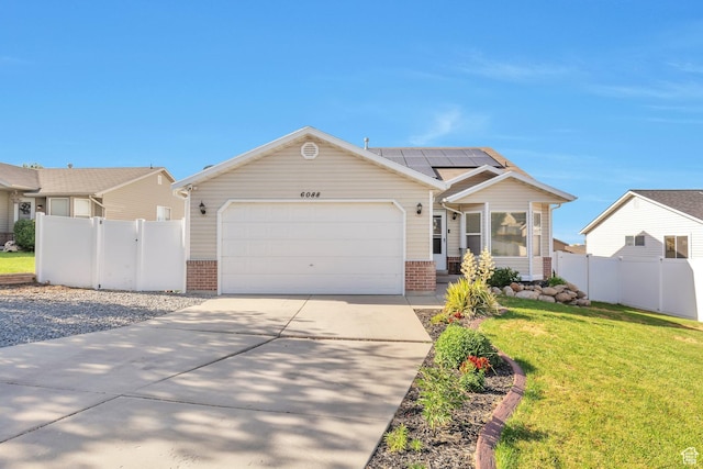 6088 W Graceland Way, West Jordan, UT 84081 - ranch-style house with brick siding, roof mounted solar panels, driveway, and an attached garage
