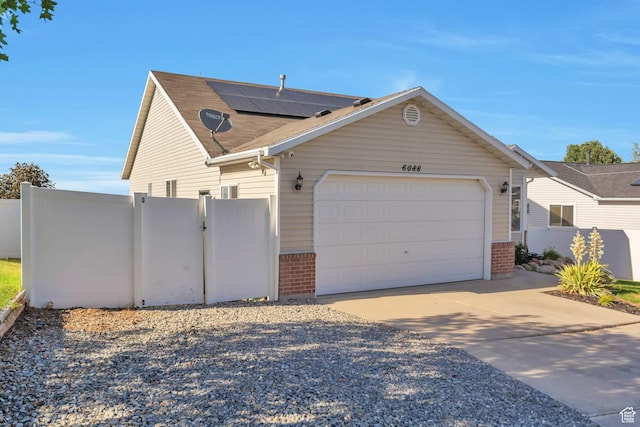 6088 W Graceland Way, West Jordan, UT 84081 - view of front of home with brick siding, a garage, concrete driveway, and solar panels