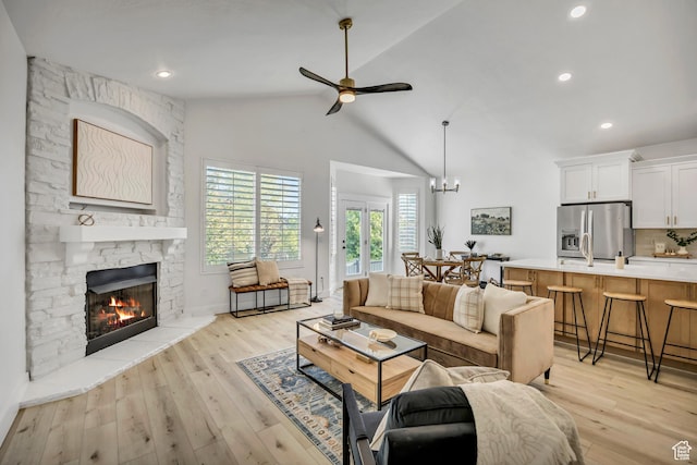 468 W Sunnyrise Ln S, Stansbury Park, UT 84074 - living area with a fireplace, a ceiling fan, light wood-type flooring, high vaulted ceiling, and a chandelier