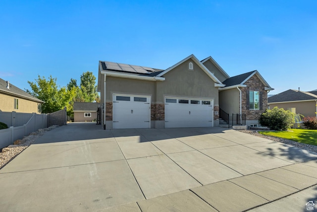 468 W Sunnyrise Ln S, Stansbury Park, UT 84074 - view of front of house featuring stone siding, stucco siding, roof mounted solar panels, and driveway
