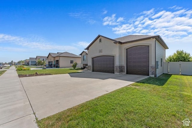 1717 N 4325 W, West Point, UT 84015 - view of property exterior featuring driveway, a garage, stone siding, and a gate