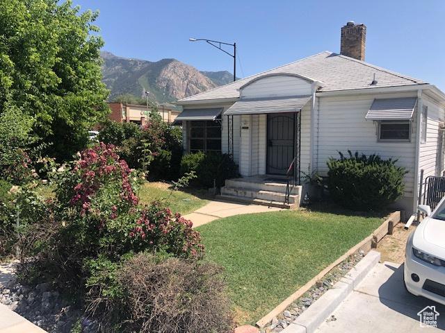 1191 E 20th, Ogden, UT 84401 - view of front of home with a mountain view, a front yard, and a chimney