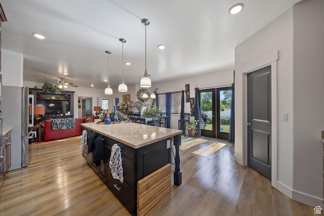 3601 S 5650 W, West Valley City, UT 84128 - kitchen featuring recessed lighting, freestanding refrigerator, open floor plan, a center island, and light stone countertops
