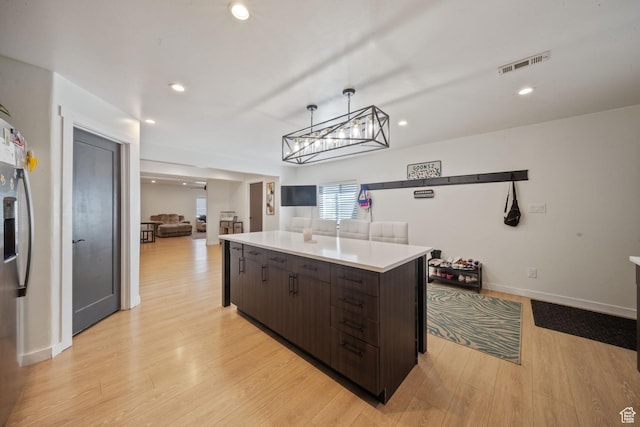 3601 S 5650 W, West Valley City, UT 84128 - kitchen featuring dark brown cabinets, a kitchen island, light countertops, light wood-type flooring, and recessed lighting
