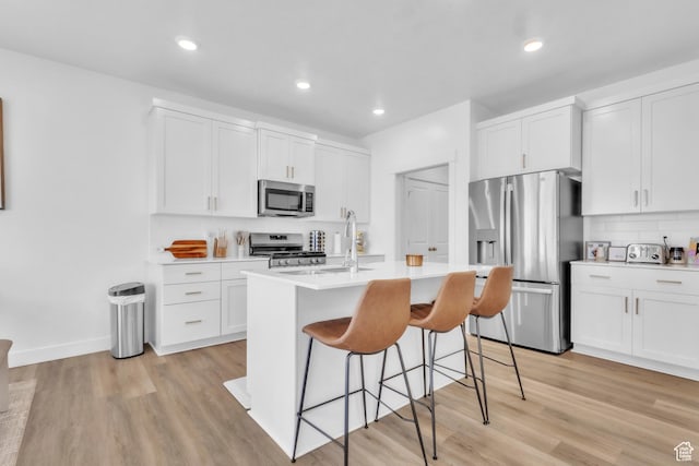 631 W 550 N, Smithfield, UT 84335 - kitchen with stainless steel appliances, a kitchen bar, light countertops, light wood-style floors, and white cabinets