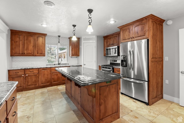 341 E 700 N, Spanish Fork, UT 84660 - kitchen featuring appliances with stainless steel finishes, tasteful backsplash, a center island, decorative light fixtures, and dark stone countertops