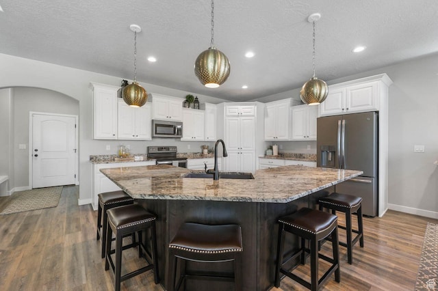 5671 S 650 E, Washington Terrace, UT 84405 - kitchen featuring stainless steel appliances, dark wood finished floors, white cabinets, recessed lighting, and a large island with sink
