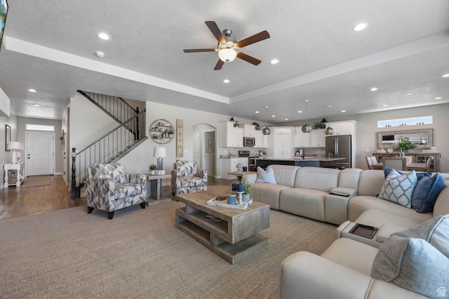 5671 S 650 E, Washington Terrace, UT 84405 - carpeted living room featuring a ceiling fan, a textured ceiling, recessed lighting, stairway, and arched walkways