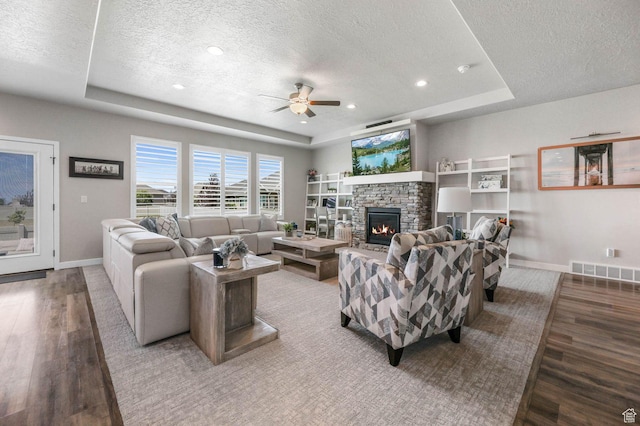 5671 S 650 E, Washington Terrace, UT 84405 - living area featuring a tray ceiling, a textured ceiling, wood finished floors, ceiling fan, and a fireplace