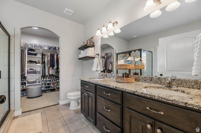 5671 S 650 E, Washington Terrace, UT 84405 - bathroom featuring a walk in closet, double vanity, a stall shower, and tile patterned floors