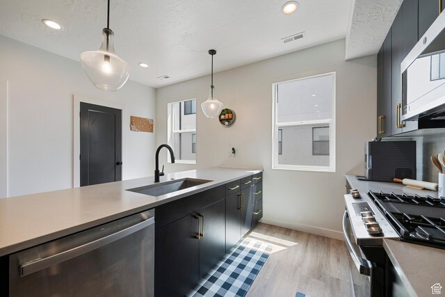 507 W 620 N Unit 127, Centerville, UT 84014 - kitchen featuring appliances with stainless steel finishes, light wood-style floors, decorative light fixtures, dark cabinetry, and recessed lighting