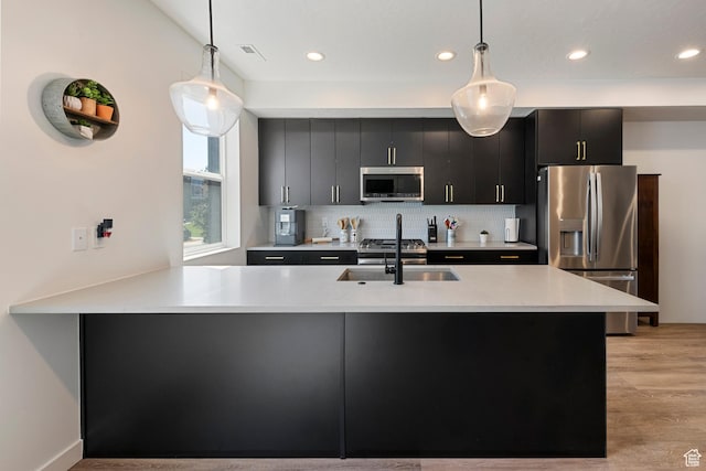 507 W 620 N Unit 127, Centerville, UT 84014 - kitchen with appliances with stainless steel finishes, dark cabinets, light wood finished floors, light countertops, and recessed lighting