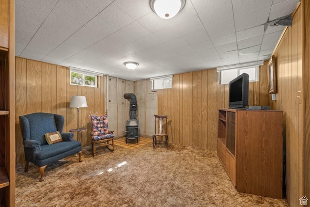 1243 Oak St, Ogden, UT 84401 - sitting room featuring a wood stove, wood walls, healthy amount of natural light, and carpet