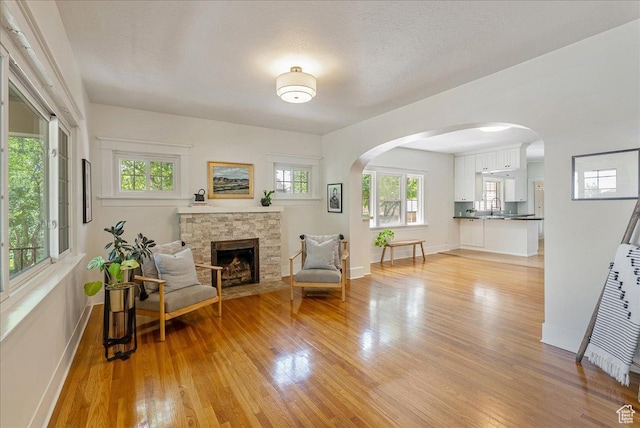 1351 E Browning Ave S, Salt Lake City, UT 84105 - living area with light wood-style floors, a fireplace, and arched walkways