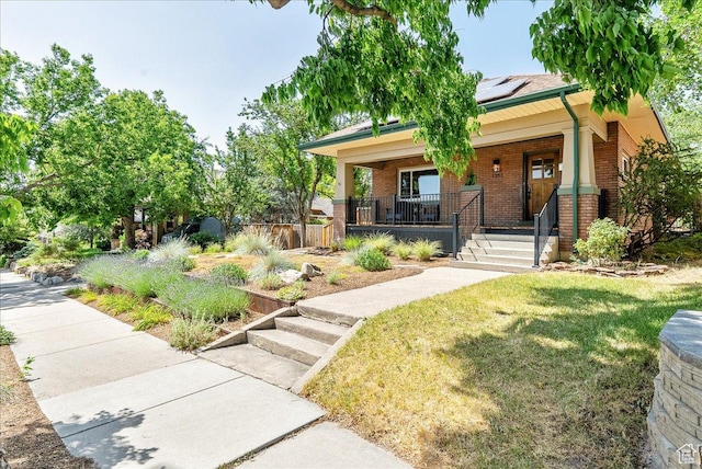 1351 E Browning Ave S, Salt Lake City, UT 84105 - view of front of home featuring brick siding, a porch, a front lawn, and solar panels