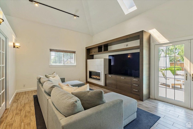 1351 E Browning Ave S, Salt Lake City, UT 84105 - living room with track lighting, a skylight, light wood-style flooring, a fireplace, and high vaulted ceiling