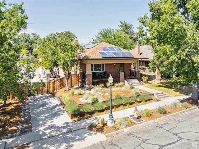 1351 E Browning Ave S, Salt Lake City, UT 84105 - view of front facade featuring a porch, solar panels, brick siding, and a chimney