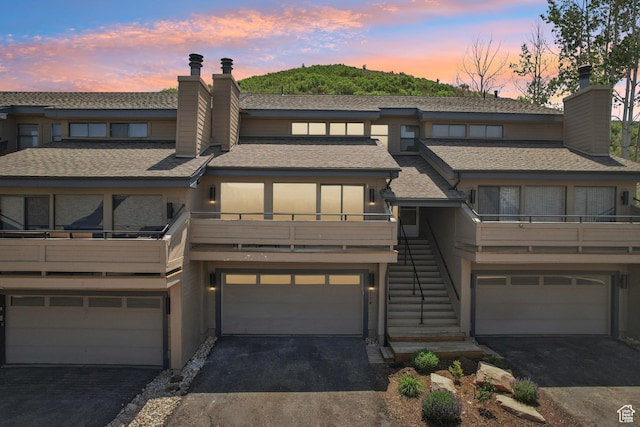 2174 Fenchurch Dr, Park City, UT 84060 - view of front of home featuring a chimney, a garage, driveway, and stairway