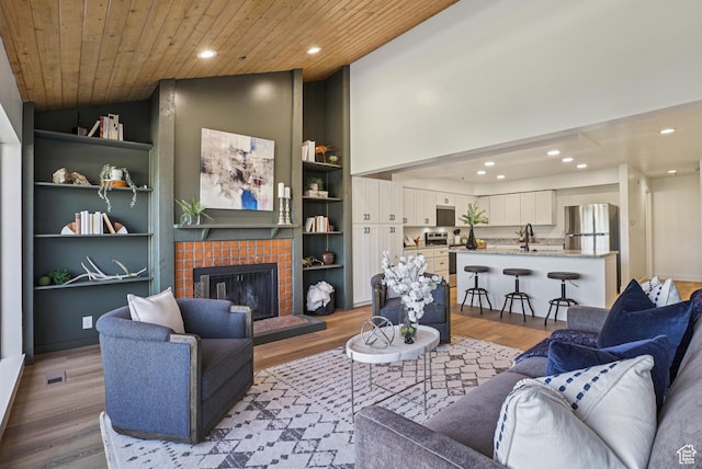 2174 Fenchurch Dr, Park City, UT 84060 - living room with wood finished floors, recessed lighting, wooden ceiling, a tiled fireplace, and built in shelves