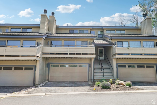 2174 Fenchurch Dr, Park City, UT 84060 - townhome / multi-family property featuring a chimney, a balcony, an attached garage, and driveway