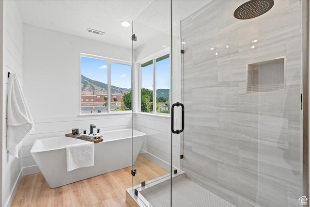 692 E Country Breeze Cir S, Draper, UT 84020 - bathroom with a shower stall, a freestanding bath, a mountain view, wood finished floors, and recessed lighting