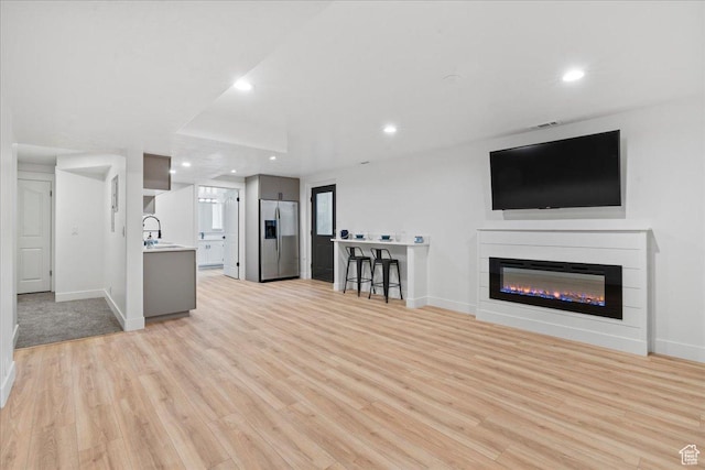 692 E Country Breeze Cir S, Draper, UT 84020 - unfurnished living room featuring light wood-type flooring, recessed lighting, and a glass covered fireplace