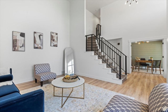 692 E Country Breeze Cir S, Draper, UT 84020 - living room featuring a high ceiling, a chandelier, wood finished floors, and stairway