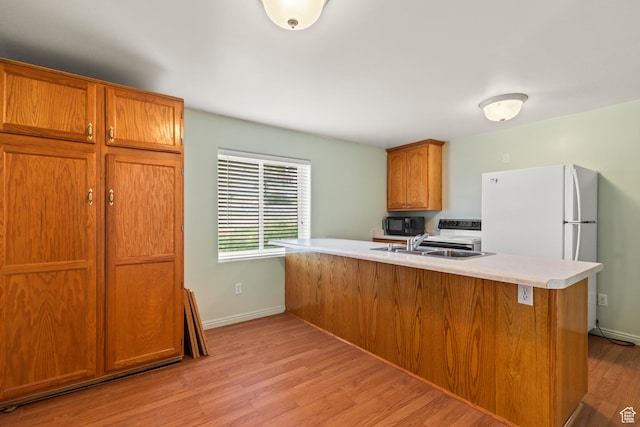 890 E Monroe Canyon Rd S, Monroe, UT 84754 - kitchen featuring light wood-style floors, light countertops, brown cabinets, and black microwave