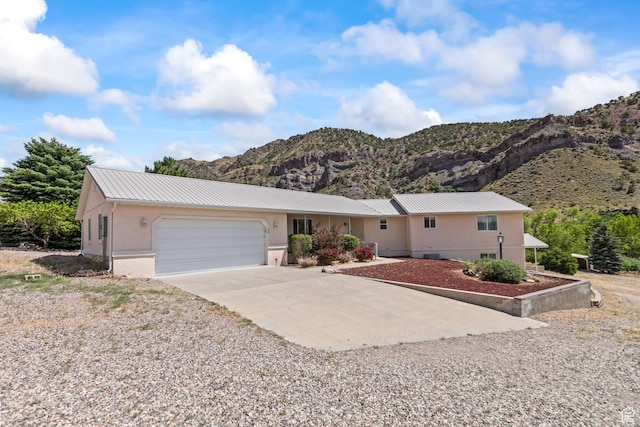 890 E Monroe Canyon Rd S, Monroe, UT 84754 - single story home featuring a mountain view, concrete driveway, stucco siding, a garage, and a metal roof
